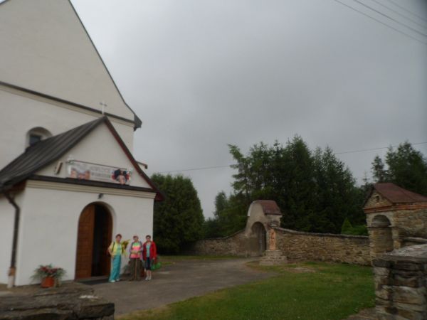 przy wejściu do kościoła, po prawej fragment muru kamiennego z bramką, przed nią na postumencie ludowa rzeźba Chrystusa Frasobliwego, wcześniej w murach kaplicz