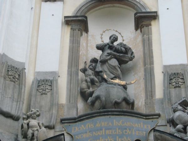 Bezpośrednio nad portalem głównym - piaskowa rzeźba przedstawiająca Najświętszą Marię Pannę Niepokalaną