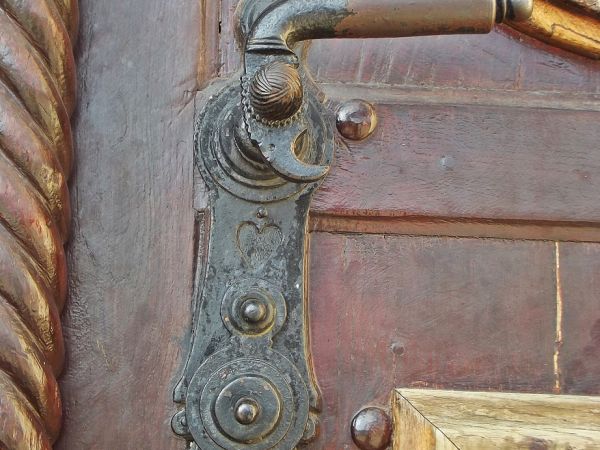 zamek z klamką w drzwiach do kościoła - kunszt kowalsko-ślusarskiej roboty.