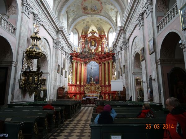 w bogatym wnętrzu kolegiaty : okazały ołtarz główny , w nim obraz ze sceną Ukrzyżowania.