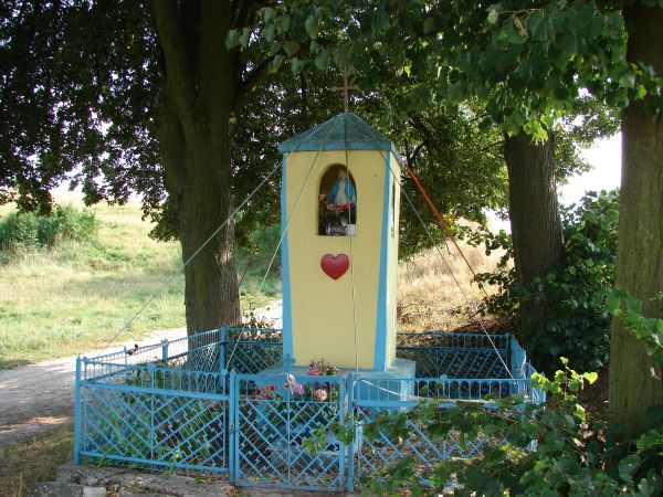 Kapliczka przydrożna,murowana,otynkowama,we wnęce figurka Matki Boskiej.