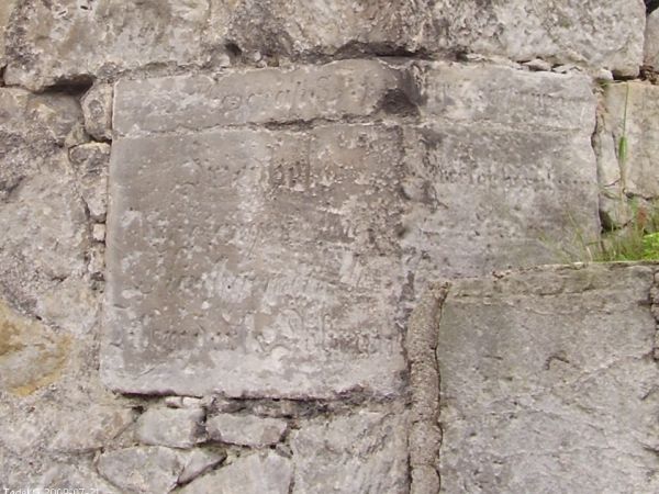 W narożniku tego muru wbudowany kamień erekcyjny z zatartym częściowo tekstem "Friedhof der evangelischen Kirchgemainde Tillendorf & Dobrau"