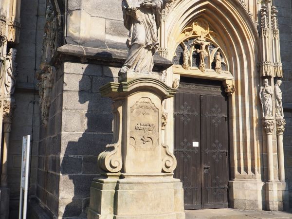 figura św. Jana Nepomucena - przed katedrą, barokowa rzeźba wystawiona w 1727r. ,  na cokole pod  figurą z przodu : męczeńska śmierć w nurtach Wełtawy - zrzucen