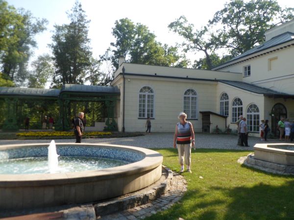 przed pałacem : fontanny a po lewej przybudowana do obiektu oranżeria a dalej pięknie urządzony park ze stawem, w pałacu po wojnie był internat szkoły rolniczej