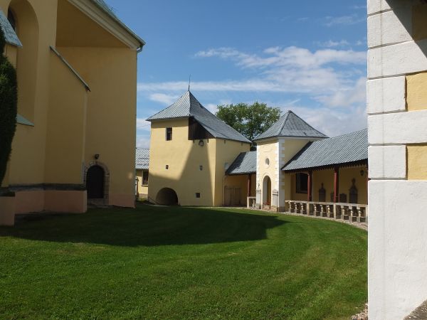 Kościół otoczony jest krużgankami których ściany zewnętrzne tworzyły mur obronny