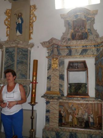 pani przewodnik prezentuje ukrytą za obrazem chrzcielnicę - n/z w niszy widoczna czara, wyżej obraz przedstawia - ze Starego Testamentu - obrzezanie, czyli naci