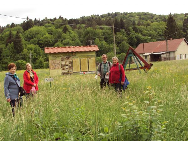 przy planszy reklamującej walory turystyczne wsi i okolicy, obok : część kiwonu kopalnianego - dotyczy wydobywania ropy naftowej.