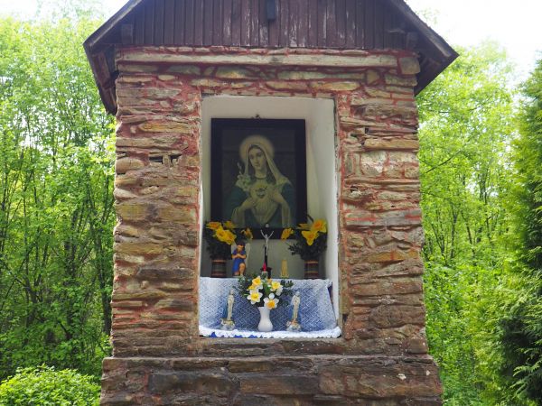 kapliczka przydrożna, zabytkowa, z kamienia - w głębokiej niszy obraz Matki Bożej Miłosiernego Serca i krucyfiks ołtarzykowy. Kapliczka przystrojona, zadbana, o