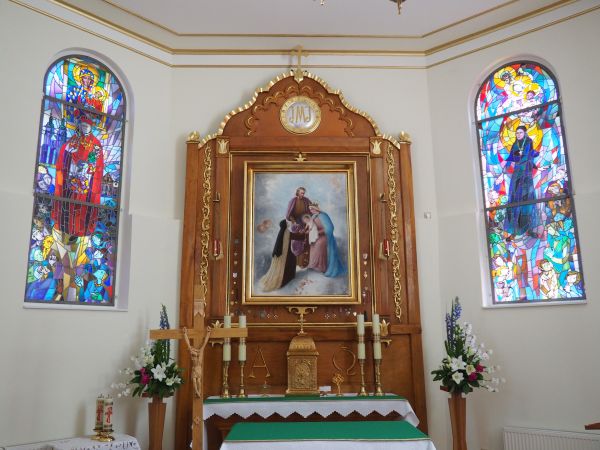 obraz przedstawiający scenę, jak to siostra zakonna nazaretanka z umiłowaniem  wita Świętą Rodzinę, chce wziąć na ręce Dzieciątko - tu w ołtarzu kaplicy klaszto