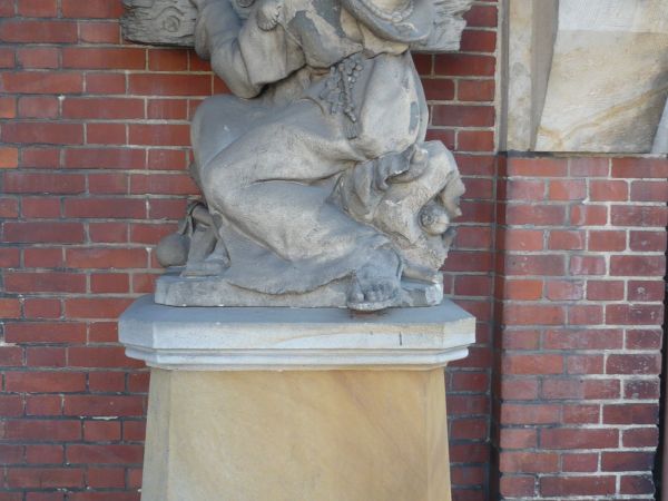 Pod kolumnadą w południowej części Konkatedry rzeźba Władysława Marcinkowskiego z1890r przeniesiona ze starego cmentarza.