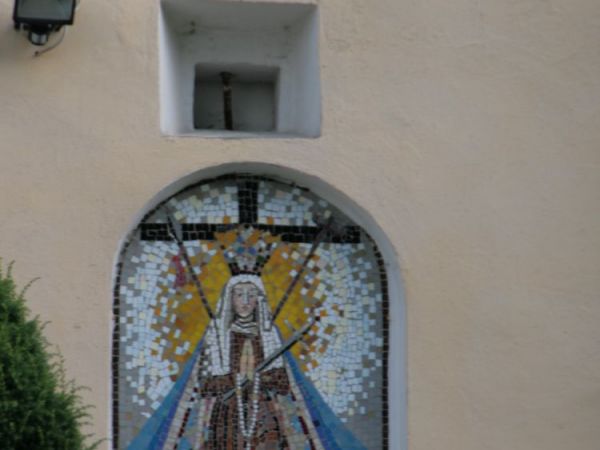 Po wewnętrznej stronie muru, znajduje się szereg epitafiów i płyt nagrobnych. Na teren kościoła prowadzi okazały, ale skromny w swym wyglądzie budynek bramny z