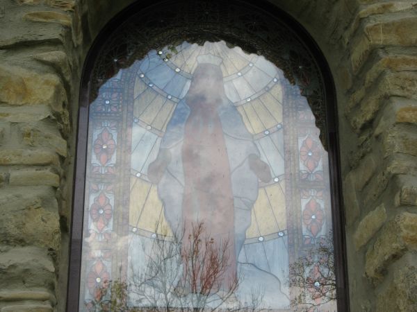 okno zamknięte półkoliście, w nim witraż - współczesne.