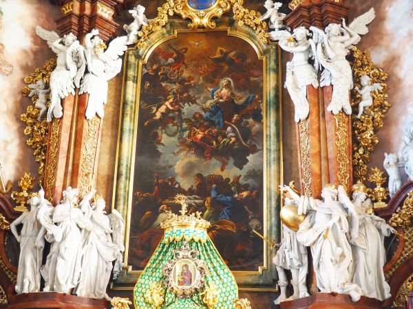 aniołowie adorują Madonnę unoszoną do nieba - w centralnym obrazie ołtarza głównego, niżej w koronie prezentowany : cudami słynący obraz Matki Bożej Łaskawej.