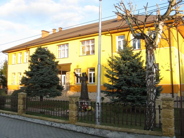 na zdjęciu: przed szkołą pomnik patrona św. Jana Pawła II-go.