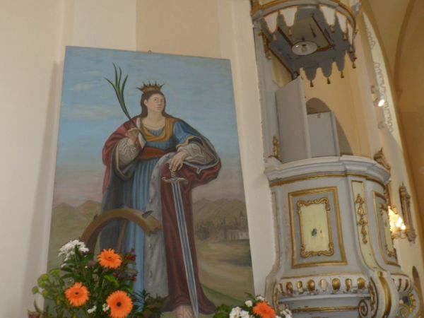 kościół jest pod wezwaniem św. Katarzyny Aleksandryjskiej - tu na obrazie, obok narzędzia tortur i miecz, którym była ścięta - w ikonografii przedstawiana jest