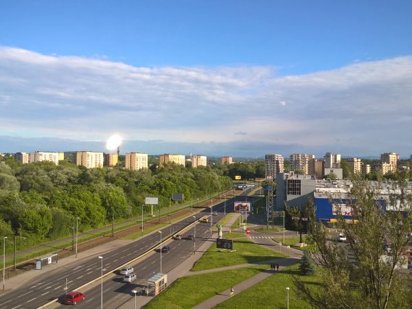 Kraków w czerwcowym słońcu u  ul.Kapelanka.z 7 pietra .Foto przez szybę, ten błysk nad blokami jest  prawdziwy , lampy błyskowej odbitej .