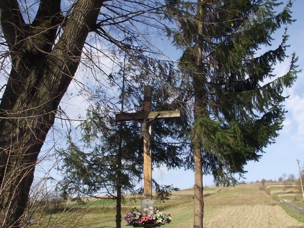 krzyż powstańczy - osadzony w kamiennym kurhanie, kamienie symbolizować mogą liczne bohaterskie ofiary zrywu powstańczego z lat 1863-64 a ich zespolenie i krzyż