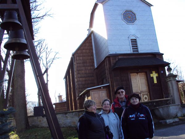 przed: kościołem parafialnym pw. św. Michała Archanioła  z 1854r., obiekt oparty na tradycyjnej w swej formie i rozplanowaniu świątyń drewnianych konstrukcji. Z