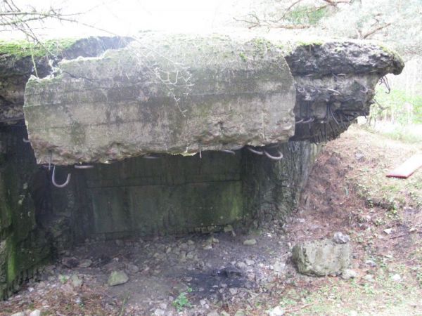 Schron nr 12 Armii "Pomorze" z 1939r. Widok od strony przelotni. Widoczne uszkodzenia spowodowane prawdopodobnym odstrzałem pancerza schronu, wskutek podłożenia
