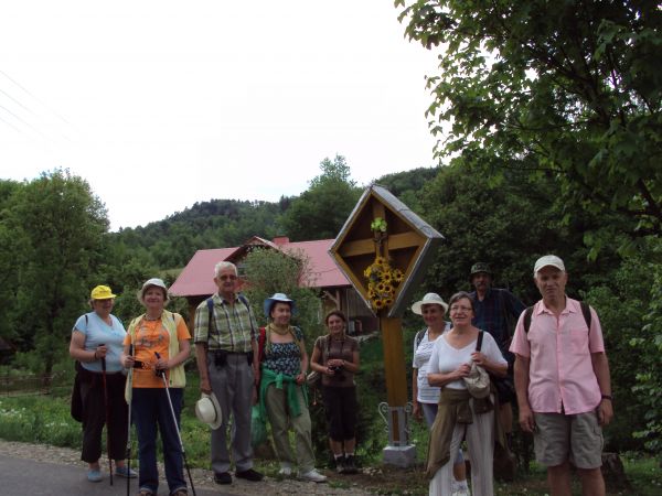 przy krzyżu drewnianym, przydrożnym z charakterystyczną osłoną - 4 takie we wsi,  na dwóch krzyżach zachowały się ludowe rzeźby Chrystusa Ukrzyżowanego.