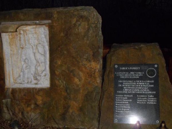 na wzgórzu przy kościele : kamienie wotywne Koła Łowieckiego "Żbik" z Ustrzyk Dolnych - po lewej scena ze św. Hubertem klęczącym przed jeleniem a w koronie poro