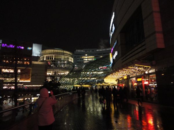 Centrum Handlowe Złote Tarasy oświetlone nocą.