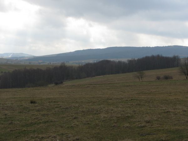 na zdjęciu: centralnie to wieś widać - to zabudowania w Woli Piotrowej a na lewo pas biały na zboczu, to wyciąg narciarski w Karlikowie, my zaś zmierzać będziem