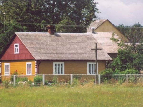 Dom drewniany wybudowany w połowie lat 30-tych XX wieku.
Krzyż wystawiony w 1945 roku.
Z tyłu po prawej budynki gospodarcze.
