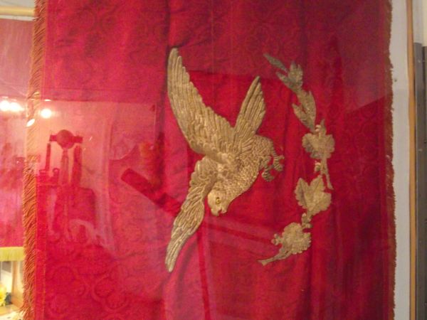 sztandar "Sokoła" - z wizerunkiem sokoła nad liśćmi dębowymi, na drzewcu wbito 234 pamiątkowych gwoździ, sztandar poświęcono w 1909r. - prezentowany na ekspozyc