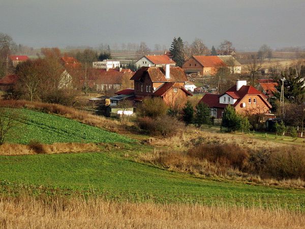 Pieckowo-widok ze wzgórza,zbliżenie (zoom) na południowo-zachodnią częsć miejscowości,Na pierwszym planie dwa budynki dawnej stacji kolejowej w Pieckowie na tra