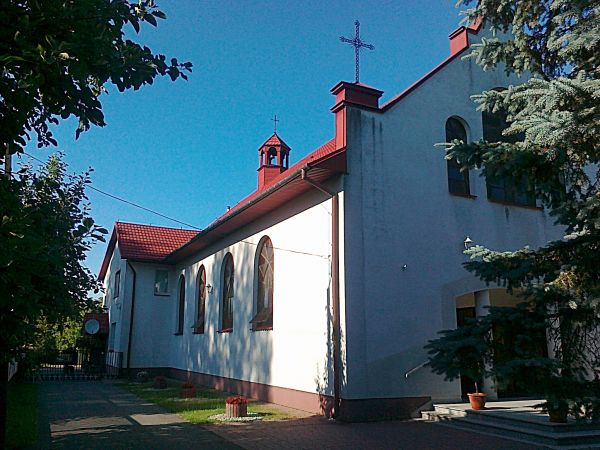 Kościół Parafialny Najświętszej   Marii Panny Królowej Polski w promieniach zachodzącego słońca .