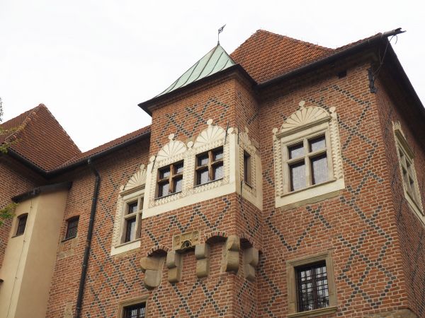 okna i nadwieszony wykusz - pięknie zdobione, wyjątkowo silny nacisk na dekoracyjność, widoczny w kontraście kolorystycznym materiałów budowlanych oraz w rozmai