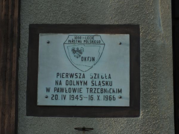 Pamiątkowa tablica na ścianie szkoły