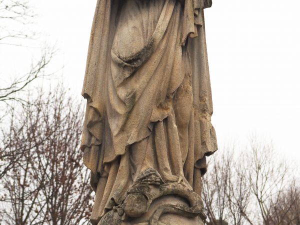 figura Matki Boskiej na cokole pomnika nagrobnego - cmentarz przy świątyni.