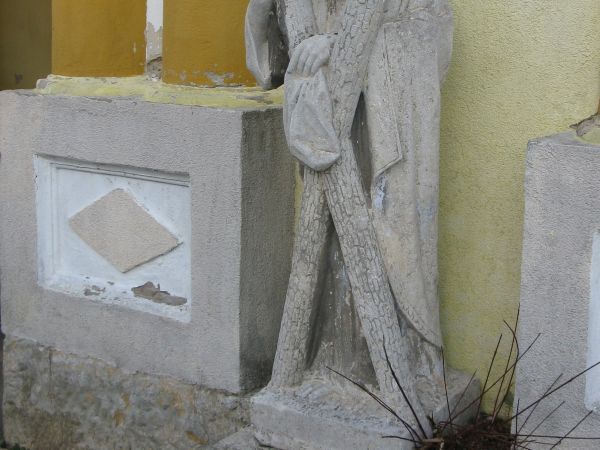 przed dzwonnicą: rzeźba św. Andrzeja - wzm. w 1872r. /ze zburzonej bramki cmentarnej/. Święty - m.in. patron Rumunii - ok. 60 roku n.e. został rozpięty na krzyż