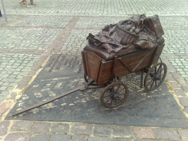 Żeliwny wózek upamiętniający kręcenie w Toruniu scen do filmu Jerzego Hoffmana i Edwarda Skórzyńskiego "Prawo i pięść” stoi  na Rynku Nowomiejskim.