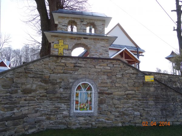 Figurka Matki Boskiej Niepokalanie Poczętej w oszklonej grocie w zabudowie schodów do kościoła /byłej cerkwi/ przez dzwonnicę bramną parawanową - prowadzących.