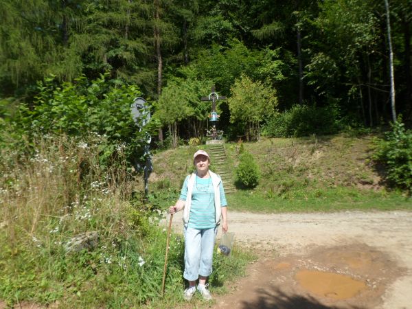 obok krzyża wotywnego na skraju lasu, przy ul. Gajowej do wsi Liszna zmierzającej, nad byłym poligonem. Z informacji przewodnickich wynika, iż krzyż stanowi wot