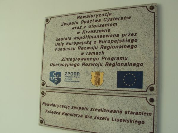 przy wejściu / w bramie zespołu opactwa Cystersów - j/w. Tędy : furta główna do sanktuarium Matki Bożej Łaskawej.