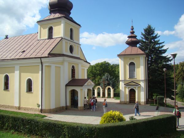 kościół pw. Najświętszej Maryi Panny Wspomożenia Wiernych, dzwonnica i na prawo most nad Pielnicą.