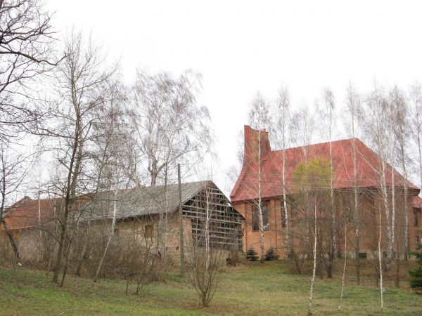 z parku: widok na budowany kościół i pozostałości gospodarskich dworskich obiektów.