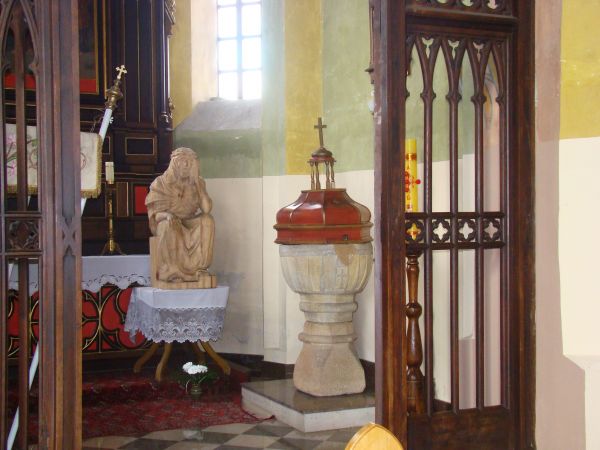 Chrzcielnica kamienna w kształcie kielicha - 1-sza poł. XVIII wieku, z drewnianą pokrywą - z XIX wieku, obok na stoliku rzeźba "Chrystus Frasobliwy" - współczes