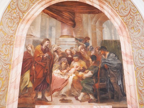 Scena przedstawia : Maryja i Józef oddają Jezuska medykom - ci przeprowadzą  zabieg obrzezania. Na polichromii jedna z osób - po prawej - prezentuje twarz artys