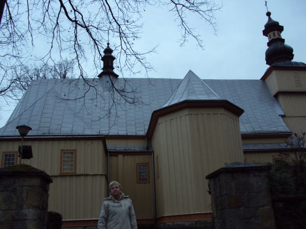 przed / obok: kościół parafialny pw. Wszystkich Świętych, w stylu gotyckim, drewniany, pochodzący z 1464r. a rozbudowany w XVII i XIX wieku. Nad kruchtą wieża k