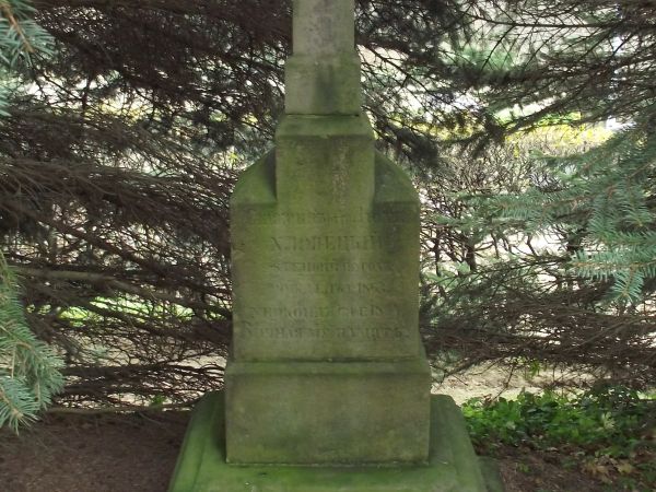 krzyż nagrobny, kamienny, na postumencie, z wyrytą inskrypcją - na cmentarzu wyznawców obrządku greko-katolickiego.