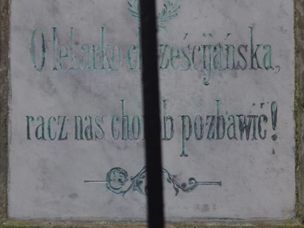 tablica wotywna na postumencie z figurą Matki Boskiej Przedziwnej - statua z 1891 roku, wyżej fragment ornamentyki - wici roślinnej ze wstążkami, w treści : "O