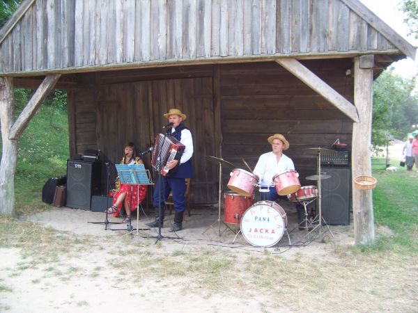 Zwiedzającym skansen przygrywa kapela ludowa.