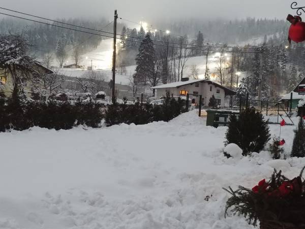 Widok z domków na oświetany stok narciarski, gondolę oraz wyciągi kanapowe w ośrodku SMR i COS