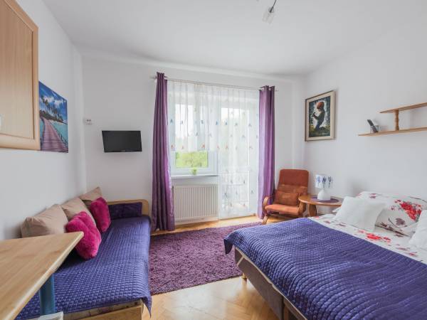 Widok pokoju 2 osob. z wyjściem na duży balkon, gdzie słońce świeci do zachodu.