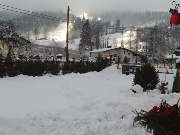 Widok z domków na oświetlany stok i gondolę